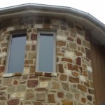 rounded gutter system on a stone house